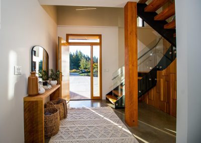 entryway with wood accents, boho details and glass railings in nanaimo home