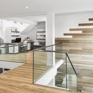 bass shoe glass railing hardware in use in a bright home with wood floors